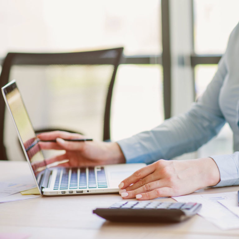 Secretary working on laptop payroll